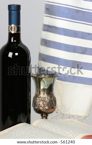 Closer view of  Holy Scriptures opened with Talid resting on it Kaddish cup and a bottle of red wine