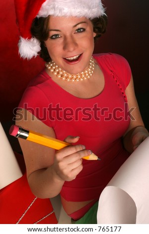 vertical of girl in santa hat is checking her list for the holidays surrounded by gifts