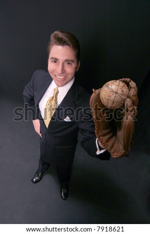 businessman holds the world in his glove on black backdrop