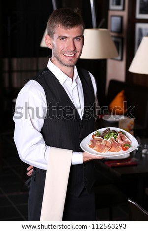 handsome man waiter in uniform at restaurant