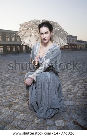 woman with umbrella in addition to columns