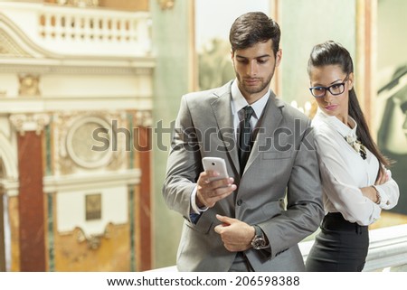 Business man and business reading a text message in the lobby of the building