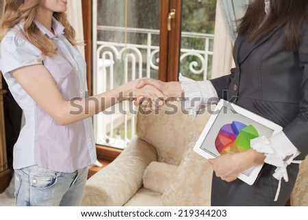 A happy couple shaking hands with their financial consultant in their home