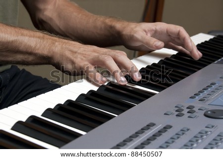 Two hands playing music on the music keyboards