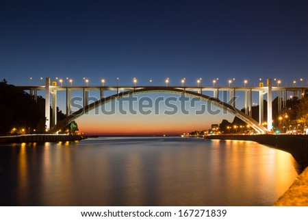 evening shot of spotlighted bridge over Douro River near coast line in historical city Porto - Portugal