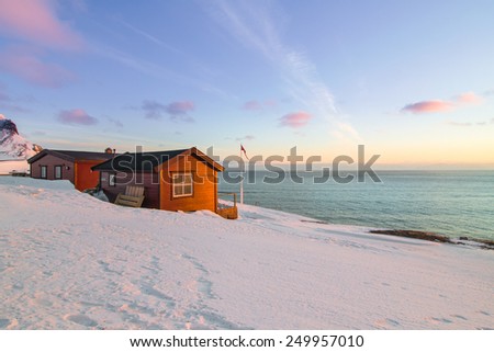 Sunset on sea coast with wooden house, Norway, the northern most settlement in the world.