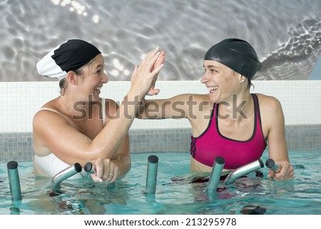 young women pedal in a training of aquabiking