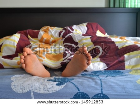 Feet of a woman sleeping on the  bed in the bedroom