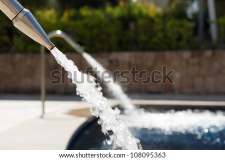 Screen of water pooring out of a fountain and falling in a swimming pool