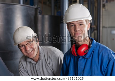 a young and an old technician both in a laugh during their work