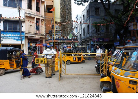MADURAI, INDIA - 28 DEC: Traffic on the street with yellow auto-rickshaws on 28 December 2010, in Madurai, India. In India, Bajaj Auto produced auto-rickshaws under Piaggio license from 1959 to 1974.