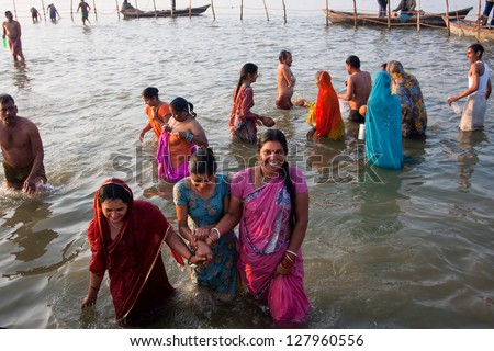 ALLAHABAD, INDIA - JANUARY 27: Three indian women come from the cold water after swimming in the holy Sangam during the biggest festival in the world - Kumbh Mela on January 27 2013 in Allahabad India