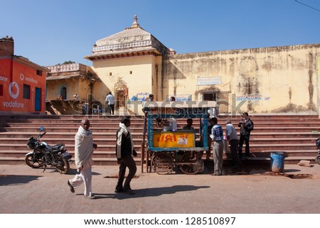 ORCHHA, INDIA - DEC 20: Indian adults have lunch near the mobile street stall with a food on December 20 2012 in Orchha, Madhya Pradesh, India. Orchha had a population of 10000. Males constitute 53%
