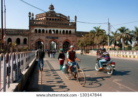 LUCKNOW, INDIA - DEC 19: Indian cyclist drives past the famouse gateway Rumi Darwaza at the sunny day on December 19, 2012 in Lucknow, India. Lucknow in Uttar Pradesh state has population of 4,588,455