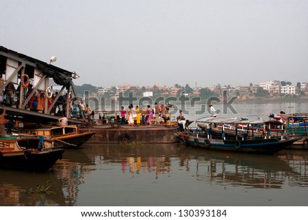 KOLKATA, INDIA - JAN 15: Passengers leave the river ferry boat at the Dakshineswar dock on January 15 2013. Third biggest indian city Kolkata with its suburbs is home to approximately 14.1 mill people