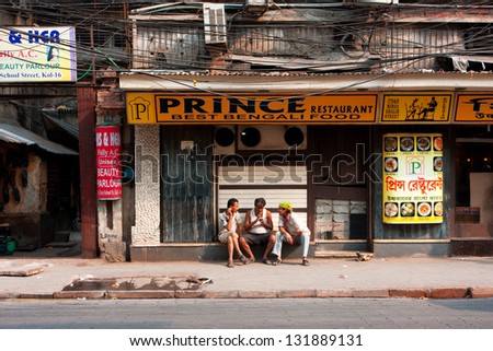 KOLKATA, INDIA - JAN 20: Three asian men talking near the closed restaurant at hot day on January 20, 2013. Third biggest indian city Kolkata with its suburbs is home to approximately 14.1 mill.people