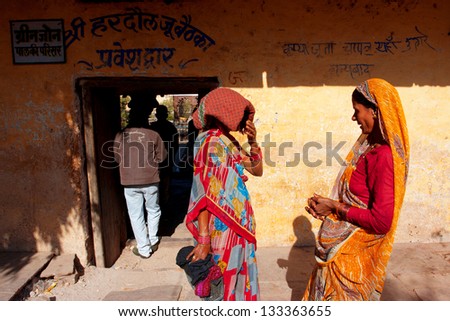 ORCHHA, INDIA - DEC 21: Two Indian women in sari talking near the temple entrance on December 21, 2012 in Orchha, Madhya Pradesh, India. Orchha had a population of 10000. Females constitute 47%