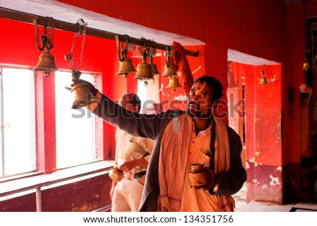 CHITRAKOOT, INDIA - DEC 29: Man rings the bell after the pray inside the hindu temple on December 27, 2013 in Chitrakoot, Madhya Pradesh, India. 92% people of Madhya Pradesh are hindus, 6% are muslim.