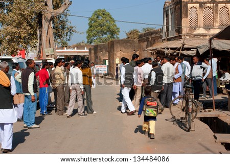 ORCHHA, INDIA - DEC 20: Asian people meet on the sunny indian street  to discuss everyday problems on December 20, 2012 in Orchha, India. Orchha had a population of 10000. Males constitute 53%.