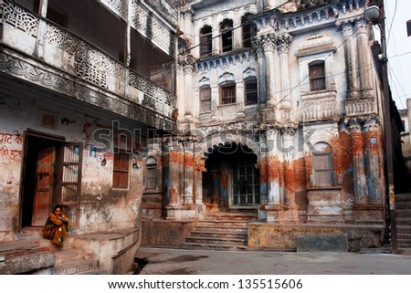 AYODHYA, INDIA - JAN 28: One woman sits on the doorstep in a beautiful crumbling Indian city on January 28, 2013 in Ayodhya, India. Ayodhya, with a population of 49,593, is birthplace of Lord Rama