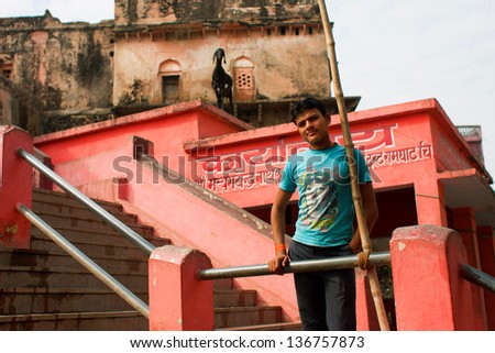 CHITRAKOOT, INDIA - DEC 29: Young asian man stands on the indian street with historical houses on December 29 2012 in Chitrakoot India. Population of Chitrakoot is 22,294. God Rama lived here 11 years