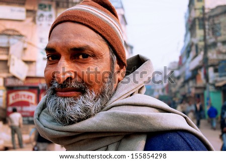 VARANASI, INDIA - JANUARY 2: Portrait of an bearded Indian passer on the crowded indian street at evening on January 2, 2013. Varanasi urban agglomeration had a population of 1,435,113