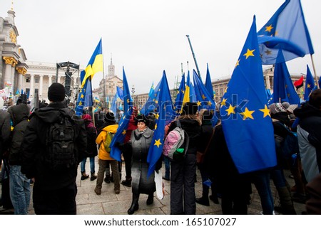 KYIV, UKRAINE - NOV 28: Woman walk past the crowd of demonstration on the Euro Maidan square and require government to sign the documents of Accession to the EU on November 28, 2013 in Kiev, Ukraine.