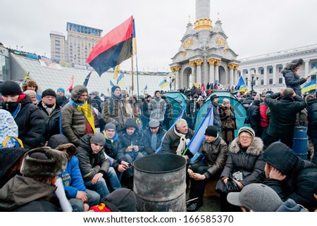 KYIV, UKRAINE - DEC 8: Many different people sitting by the fire on the crowded street during two weeks anti-government protest on December 8, 2013, in Maidan square in center of Kiev, Ukraine.