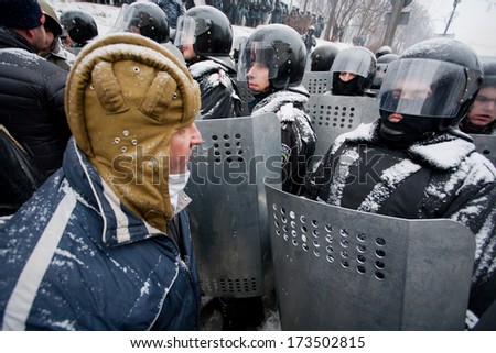 KIEV, UKRAINE - JAN 21: Revolutioner in a military helmet arguing with policemen in government quarter during winter anti-government protest Euromaidan on January 21, 2014, in Kyiv, Ukraine.