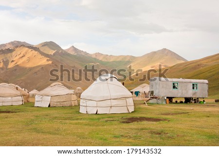 KYRGYZSTAN, CENTRAL ASIA - AUG 9: Village with traditional asian farmers tents on Tian Shan mountains background on August 9, 2013. Kyrgyzstan\'s population is 5.2 million. The country is rural