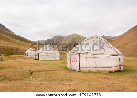 KYRGYZSTAN, CENTRAL ASIA - AUG 8: Tents Yurts - homes of the local nomadic asian people in a dry grass mountain valley on August 8, 2013. Kyrgyzstan\'s population is 5.2 million. The country is rural