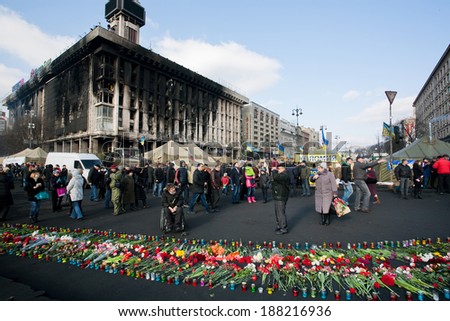 KIEV, UKRAINE - FEB 24: People with flowers ?ame past burnt building to honor the memory of 100 people were killed on the street during civil and anti-Russian protest on Fabruary 24, 2014, in Kyiv.
