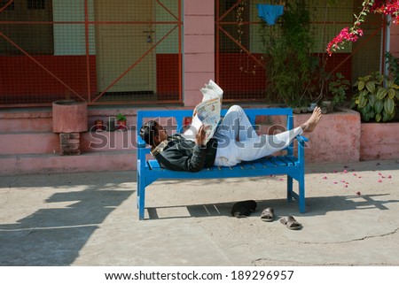 CHITRAKOOT, INDIA - DEC 29: Asian man read the newspaper outdoor at the time of siesta at hot sunny day on December 29, 2012. Population of Chitrakoot is 22,294. By the legend, Lord Rama lived here
