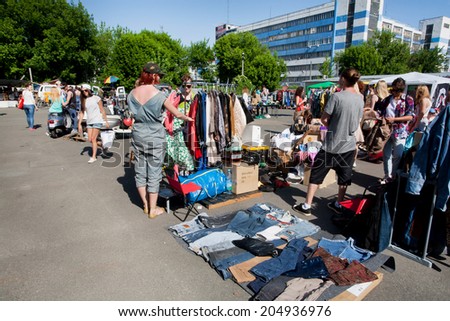 KIEV, UKRAINE - MAY 25: People looking for second hand jeans and used items on the open air flea market at sunny morning on May 25 2014. Kiev the 8th largest city in Europe with population 2,847,200