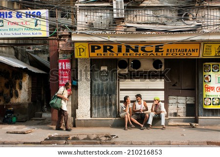 KOLKATA, INDIA - JAN 20: Poor people chating at front of indian cuisine restaurant on January 20, 2013. Third biggest indian city Calcutta with its suburbs is home to approximately 14.1 mill.people
