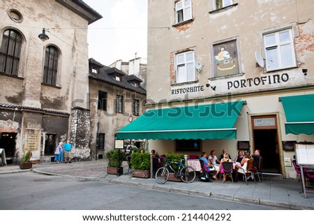 KRAKOW, POLAND - JUL 31: People have dinner in outdoor terrace of italian restaurant in old polish city on July 31, 2014. Since the 14th to the 19th century Kazimierz was an independent town