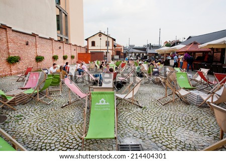 KRAKOW, POLAND - JUL 31: Summer chaise lounge and cheap furniture in outdoor cafe in urban area of city on July 31 2014. Krakow with popul. of 800,000 people has 2.35 mill. foreign tourists annually