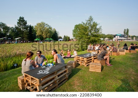 KATOWICE, POLAND - AUG 3: Youth have fun with friends and drinks on outdoor party on green area of city on August 3, 2014. Katowice lies within an urban zone, with a population of 2,746,460