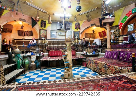ZANJAN, IRAN - OCT 7: People eat food, sitting on the traditional ottoman couches in weird interior iranian restaurant on October 7 2014. With a popul. of 400.000, Zanjan is 20th largest city in Iran
