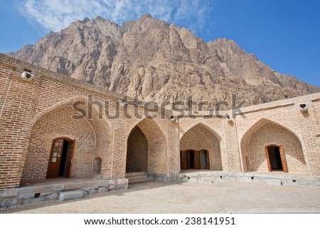 Mountain peak rises above the old building of the caravanserai in the Middle East
