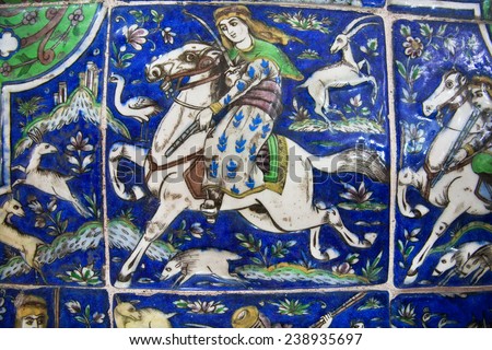 ISFAHAN, IRAN - OCT 15: Hunters during the chase on the vintage ceramic tile, preserved since the 19th century on October 15, 2014. Third largest city in Iran, Isfahan is example of Islamic culture