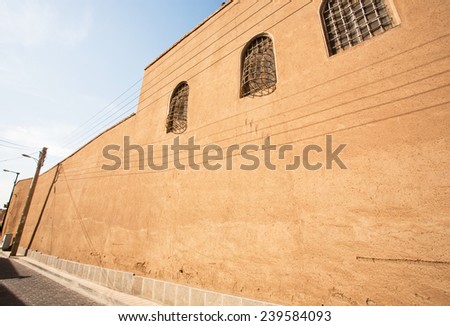 Ancient clay wall of the building with the shadow from electrical wires in the town of Middle East