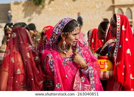 JAISALMER, INDIA - MAR 1: Woman thinking about something in a crowd of friends dressed in sari on the Desert Festival on March 1, 2015. Every winter Jaisalmer takes the Desert Festival of Rajasthan