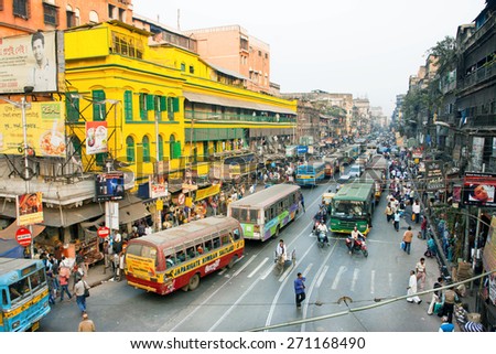 KOLKATA, INDIA - JAN 17: Colorful indin street with many buses, cars and rushing people on January 17, 2013 in West Bengal. Kolkata has a density of 814.80 vehicles per km road length