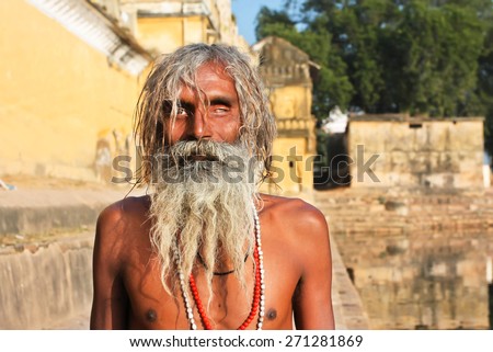 KHAJURAHO, INDIA - DEC 25: One eye blind poor man has sun bathing outdoor on December 25, 2013. The second-most populous country with over 1.2 billion people, India has 74.04% literacy rate.
