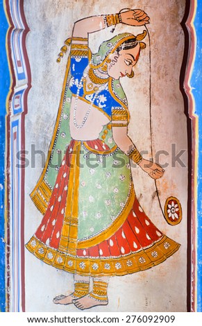 NAWALGARH, INDIA - FEB 6: Woman in indian sari plays with toy yo-yo in fresco of ancient mansion on February 6, 2015. With population of 100,000, Nawalgarh is the education center of Shekhawati region