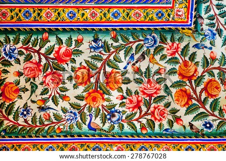 Flowers and small birds design on colorful fresco of historical mansion in Rajasthan, India