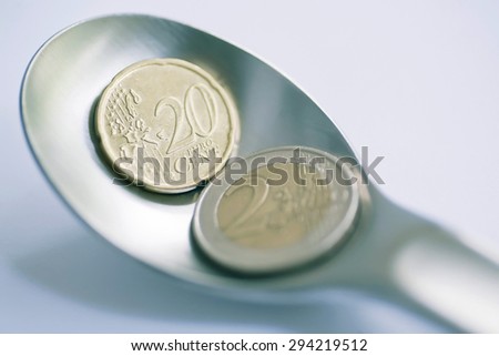 Twenty cents and two euro as an offer on a spoon. Selective focus coins of current currency of the European Union