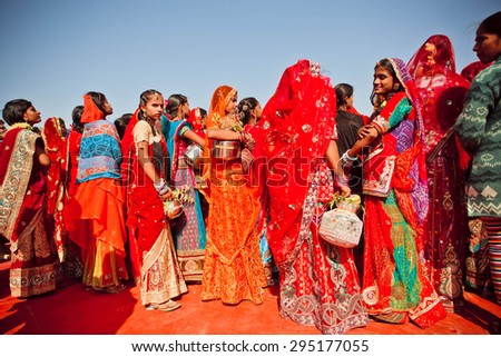 JAISALMER, INDIA - FEB 1: Colorful dressed young women in crowd of indian ladies waiting for the show on Desert Festival on February 1, 2015. Every winter Jaisalmer takes Desert Festival of Rajasthan