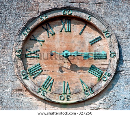 Old sandstone clock face with weathered hands & numbers